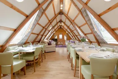 a dining room with tables and chairs in a building at Rabbie Burns Lodge in Maybole
