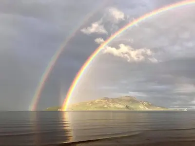 twobows over the water with a mountain in the background at Eilean View in Lamlash
