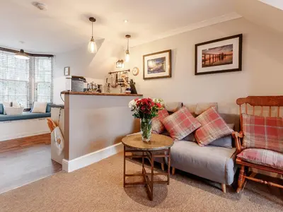 a living room with a couch and a table at Forth Reflections in Queensferry