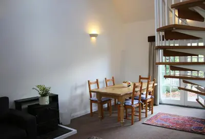 a dining room with a wooden table and chairs at Pirn Mill Self Catering Cottage in Cladich
