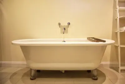 a white bath tub with a faucet in a bathroom at Pirn Mill Self Catering Cottage in Cladich
