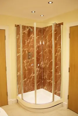 a glass shower in a bathroom with brown marble at Pirn Mill Self Catering Cottage in Cladich
