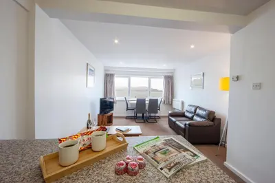 a living room with a couch and a table at Esplanade Court Holiday Apartments in Oban