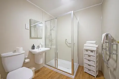 a bathroom with a shower and a toilet and a sink at Esplanade Court Holiday Apartments in Oban