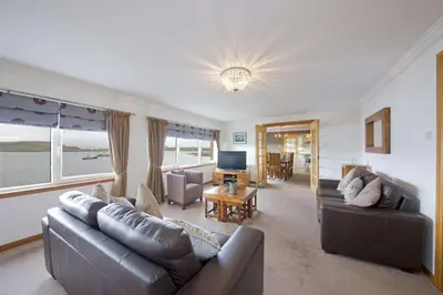 a living room with a couch and a television at Esplanade Court Holiday Apartments in Oban