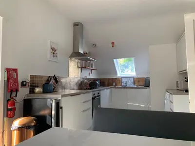a kitchen with white cabinets and a stove top oven at The Clachan Flat in Rosneath