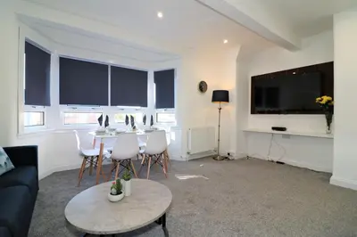 a living room with a table and chairs and a tv at Jess View in Renfrew