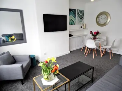 a living room with a couch and a table at Penilee Upper Apartment in Glasgow