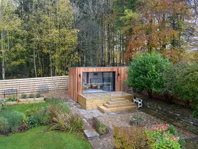 a small wooden house in the middle of a garden at Glen Rosa in Ayr