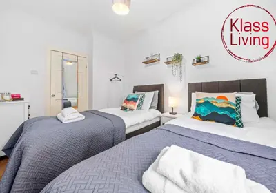 a bedroom with two beds and a sign that reads kiss living at Nicol Apartment by Klass Living Airdrie in Airdrie