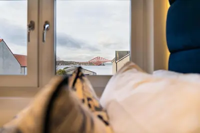 a bed with a window with a view of a bridge at The Shore in Queensferry