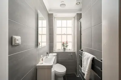a bathroom with a toilet and a sink and a window at Queensferry Street Lane - Fantastic 2 BR City Centre Mews House with free secure parking! in Edinburgh