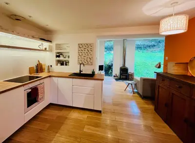 a kitchen with white cabinets and a large window at 4 Balvaig Cottage, Strathyre in Stirling
