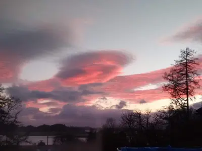 a sunset with clouds in the sky at Granite Croft in Appin