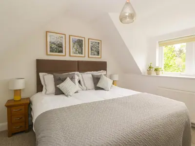a bedroom with a large white bed with pillows at Ellanderroch in Glasgow