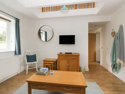 a living room with a table and a mirror at Ellanderroch in Glasgow
