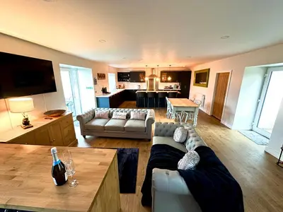 a living room with a couch and a table at The Hideaway - Farm Stay with hottub, pool table and outdoor cinema in Newmilns