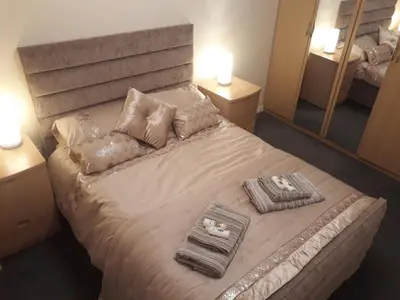 a bedroom with a bed with two towels and a mirror at Pond view in Airdrie