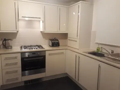 a kitchen with white cabinets and a stove and a sink at Pond view in Airdrie