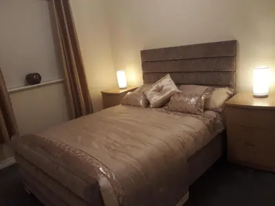 a bedroom with a bed with two lamps on it at Pond view in Airdrie
