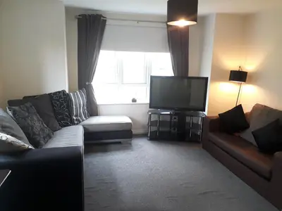 a living room with a couch and a television at Pond view in Airdrie