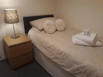 a bedroom with a bed with two pillows and a lamp at Pond view in Airdrie