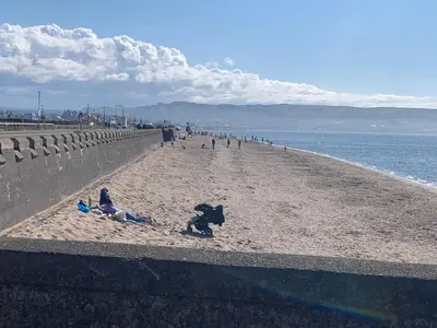 a group of people on a beach near the ocean at Ayr Loft Apartment with Fabulous Views in Ayr