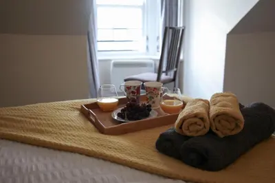 a tray of food with towels and fruit on a bed at Ayr Loft Apartment with Fabulous Views in Ayr