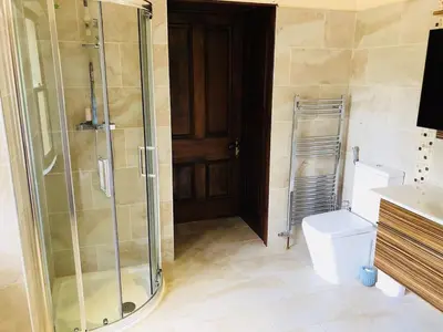 a bathroom with a glass shower and a toilet at Beautiful 4-Bed Villa in Glasgow in Glasgow