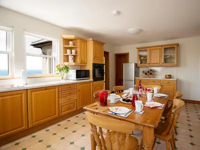 a kitchen with a wooden table with chairs in it at Cairn-O-Mhor in Lendalfoot