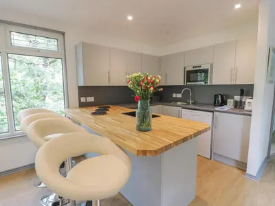 a kitchen with a table with chairs and a vase of flowers at The River Lodge in Oban