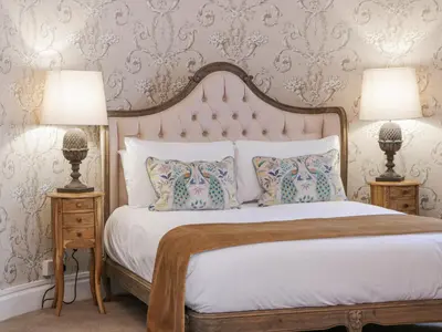 a bedroom with a large bed with two lamps at Brewhouse Flat - Culzean Castle in Maybole