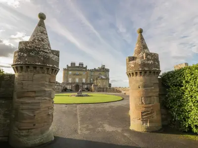 a castle with two towers in front of a building at North Segganwell - Culzean Castle in Maybole