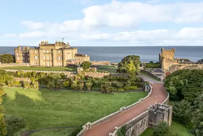 an aerial view of a castle with a road in front at South Segganwell - Culzean Castle in Maybole