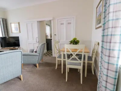 a living room with a table and chairs at Royal Artillery Cottage - Culzean Castle in Maybole