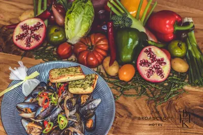 a table topped with a plate of food with vegetables at Broadcroft Hotel in Kirkintilloch