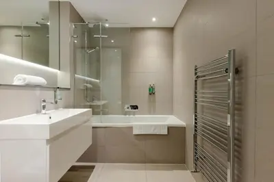 a white bathroom with a sink and a shower at Dragon Suites - Edinburgh City Centre 1 Bed Apartment in Edinburgh