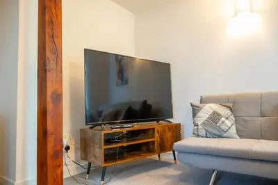 a living room with a flat screen tv and a couch at No 2 Planetree in Lochgoilhead