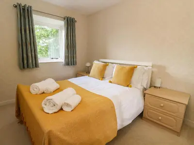a bedroom with a large bed with towels on it at Burnside House in Dalmally