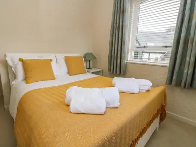 a bedroom with a large bed with towels on it at Burnside House in Dalmally
