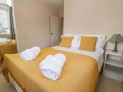 a bedroom with a bed with towels on it at Burnside House in Dalmally