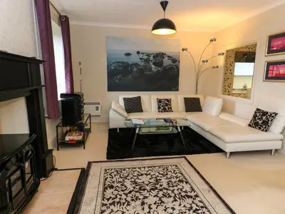 a living room with a white couch and a tv at Burnside House in Dalmally