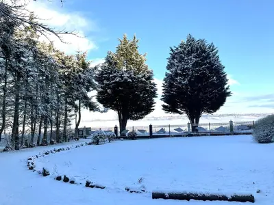 a snow covered park with trees and a fence at The Retreat Tranquil Countryside Apartment in Larkhall