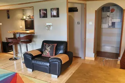 a living room with a leather chair and a stool at The Retreat Tranquil Countryside Apartment in Larkhall