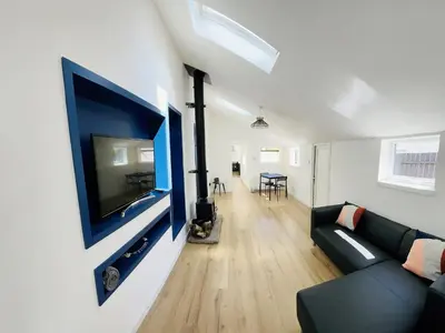 a living room with a couch and a flat screen tv at Ardrhu Cottage in Hunters Quay