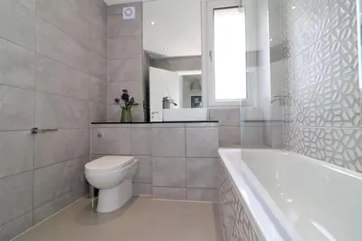 a bathroom with a toilet and a tub and a sink at Macintosh Upper in Bellshill