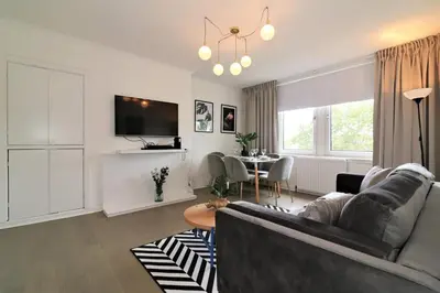 a living room with a couch and a table at Macintosh Upper in Bellshill