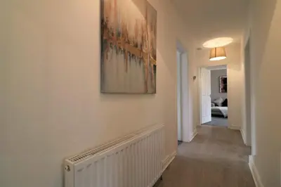 a hallway with a painting on the wall at Macintosh lower in Bellshill