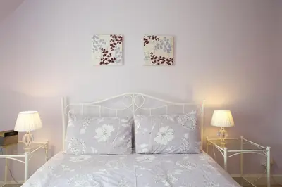 a bedroom with a bed with pillows and two lamps at Avonlea Self-Catering in Crieff