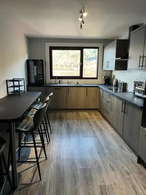 a kitchen with wooden floors and a table and chairs at Ben Arthur's Bothy Luxury Flat in Arrochar